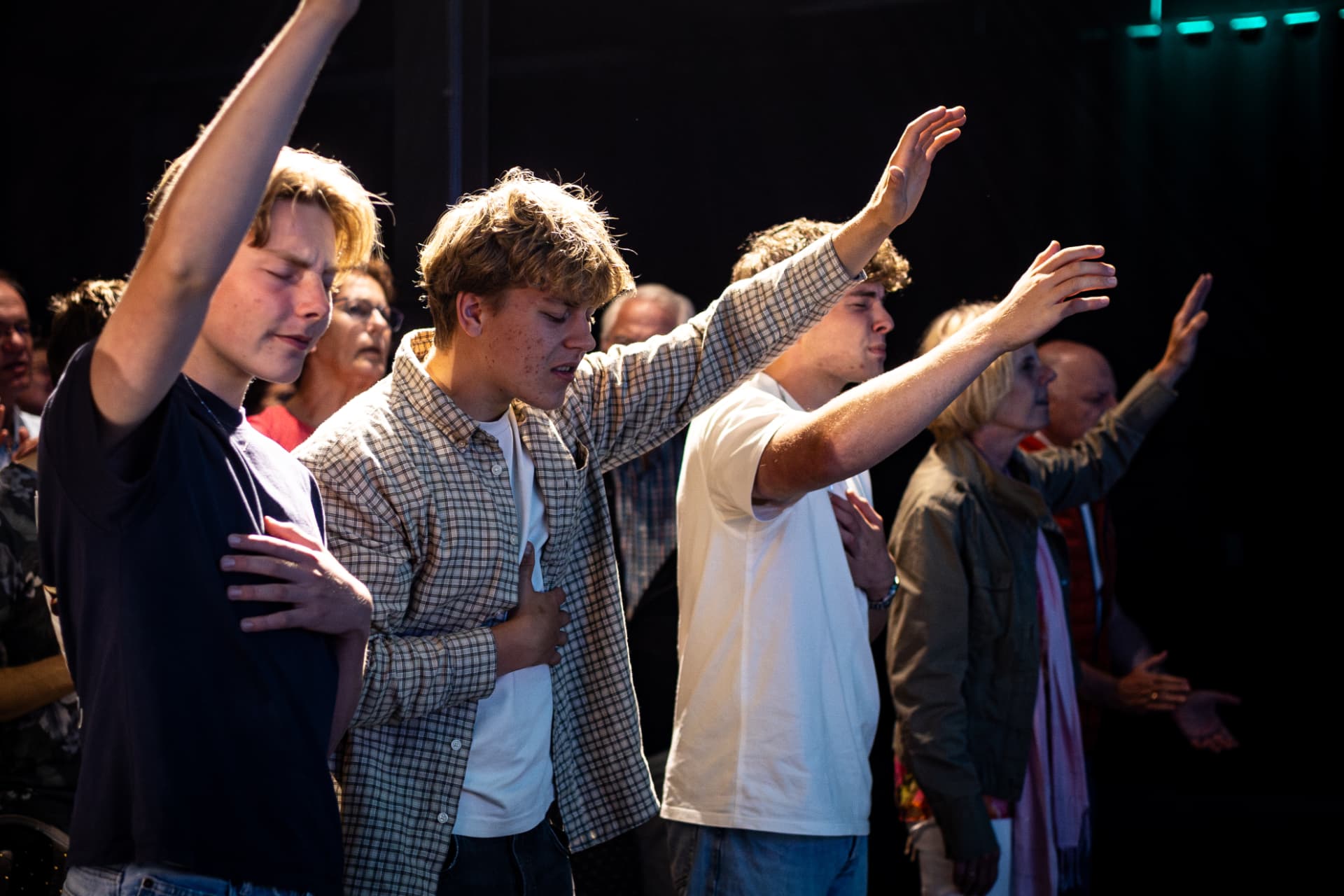 Bezoekers met opgeheven handen in aanbidding tijdens een Holy Spirit Night