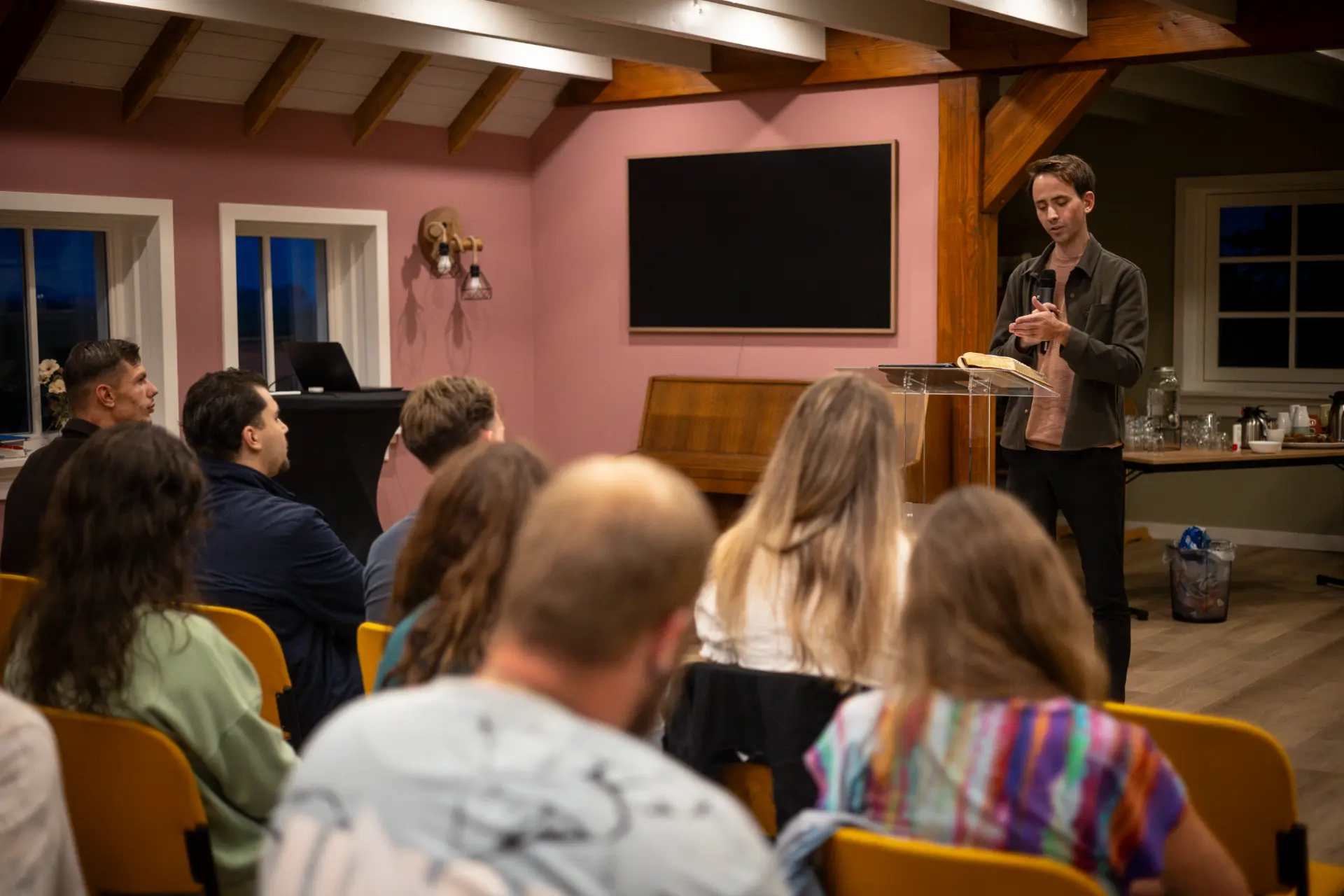 Jelthe Kloens speaking at a lectern during a Bible school meeting in Kampen